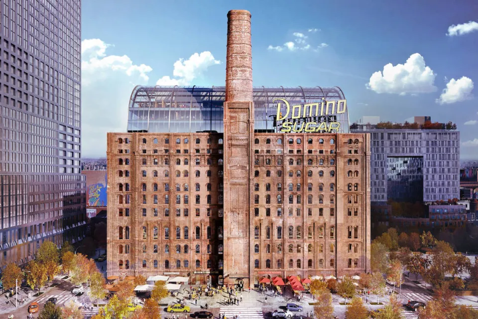 Historic brick sugar refinery building redeveloped with glass office tower inside and yellow Domino Sugar sign